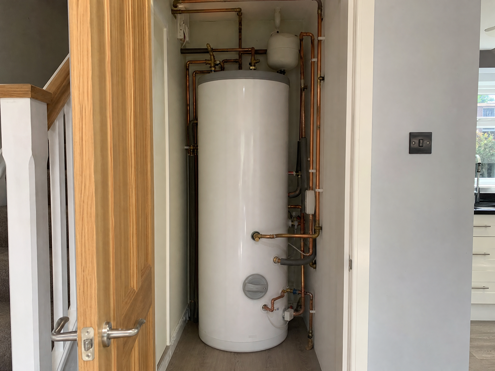Completed hot water cylinder installation showing professional quality workmanship in a British home